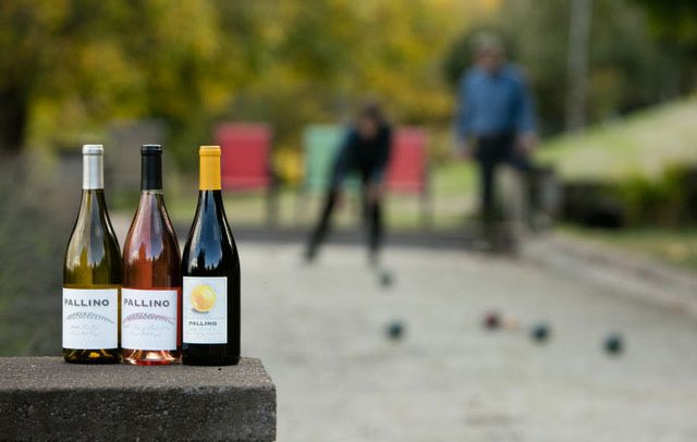 Three bottles of Pallino wine and a bocce ball court