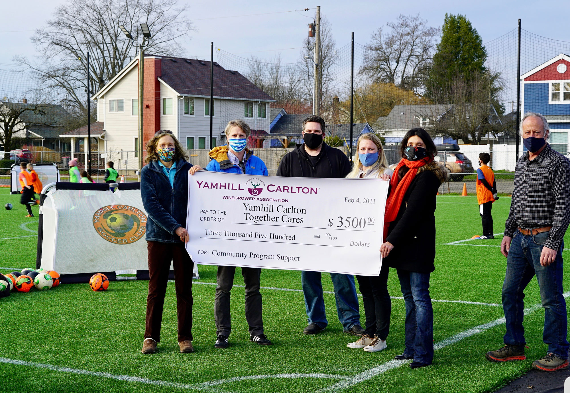 Group of people holding large check for Yamhill Carlton Together Cares